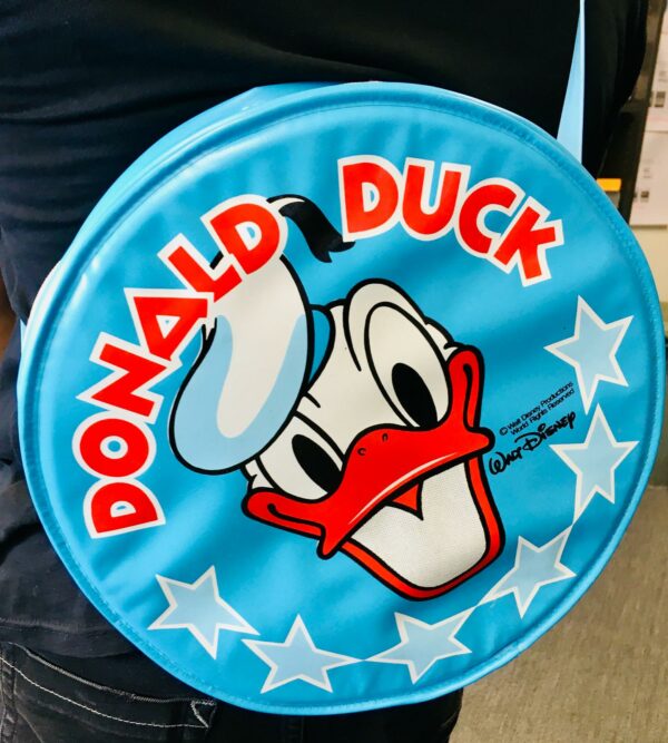 Donald Duck, Walt Disney, runde Kunststoff-Tasche | 30 cm um 1970/80 Kult retro! TOP-Zustand diese tolle Umhänge-Tasche / Schultertasche aus den 70er/80er Jahre, auch innen sehr gut. Alter geschätzt um 1970/1980, Durchmesser ca. 30 cm, Breite ca. 10 cm, Gewicht ca. 210 Gramm. Absolut rar und selten zu finden, siehe auch die Original-Fotos, Super-Zustand. Vintage Walt Disney Donald Duck Bauch-Tasche, Schultasche, Freizeittasche, Geldbörse. Donald Duck Umhängetasche von Disney unbenutzt und neuwertig! Unser Credo: SEI AUCH DU NACHHALTIG, INDEM DU UNSERE PRODUKTE EIN NEUES LEBEN SCHENKST. WIR LIEBEN NACHHALTIGKEIT, UND LEBEN NACHHALTIG ZU SEIN.