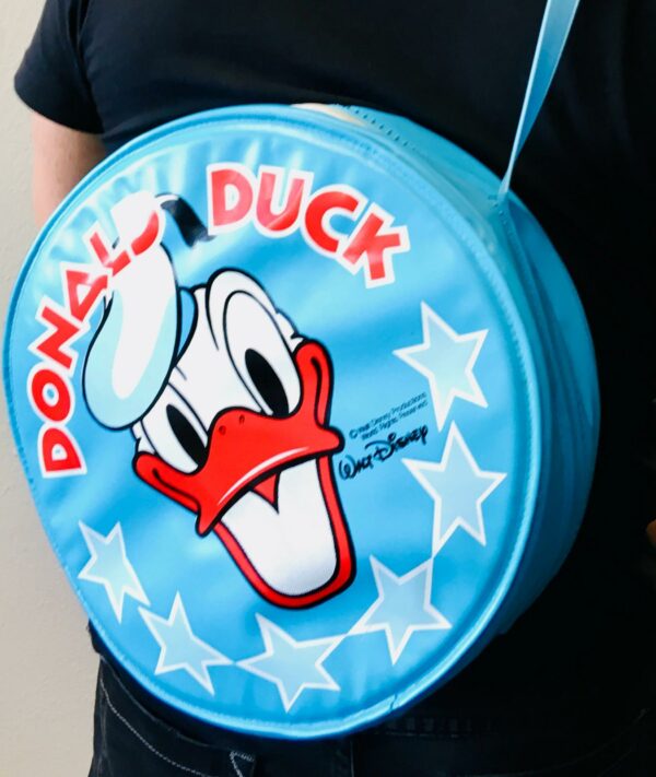 Donald Duck, Walt Disney, runde Kunststoff-Tasche | 30 cm um 1970/80 Kult retro! TOP-Zustand diese tolle Umhänge-Tasche / Schultertasche aus den 70er/80er Jahre, auch innen sehr gut. Alter geschätzt um 1970/1980, Durchmesser ca. 30 cm, Breite ca. 10 cm, Gewicht ca. 210 Gramm. Absolut rar und selten zu finden, siehe auch die Original-Fotos, Super-Zustand. Vintage Walt Disney Donald Duck Bauch-Tasche, Schultasche, Freizeittasche, Geldbörse. Donald Duck Umhängetasche von Disney unbenutzt und neuwertig! Unser Credo: SEI AUCH DU NACHHALTIG, INDEM DU UNSERE PRODUKTE EIN NEUES LEBEN SCHENKST. WIR LIEBEN NACHHALTIGKEIT, UND LEBEN NACHHALTIG ZU SEIN.